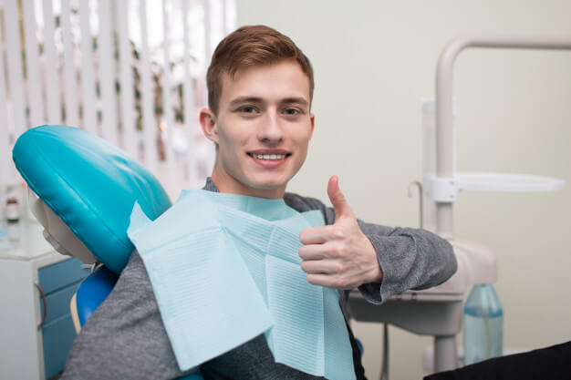 ancoragem ortodontica paciente sorrindo e fazendo joia