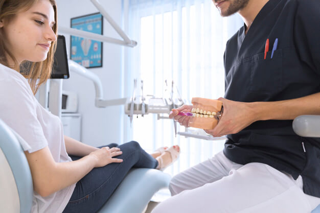 dentista mostrando como usa escova ortodôntica