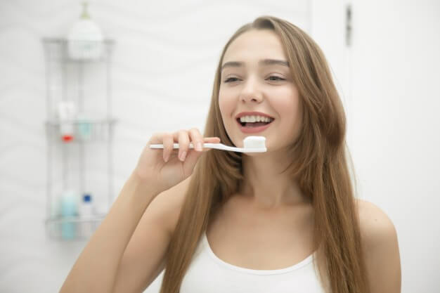 mulher sorrindo com escova ortodôntica
